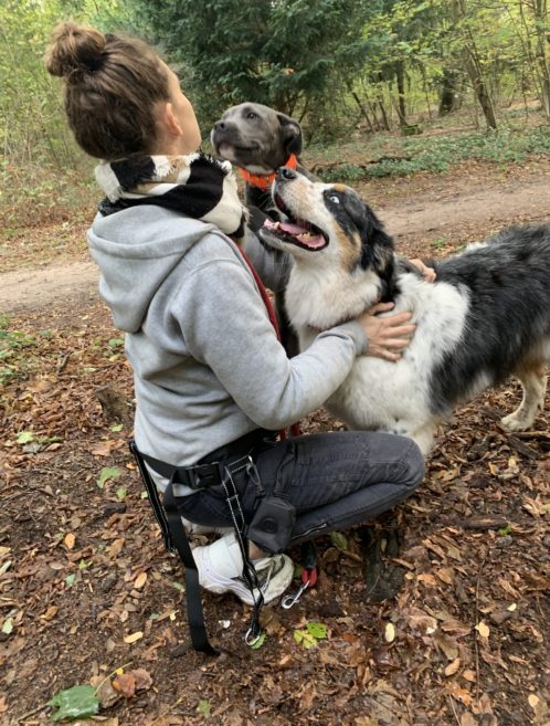 Jeune femme et deux chiens se faisant un bisou